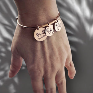 rose gold charm bracelet with 3 charms. main charm is engraved with parents first name initial and wedding date. next two charms are engraved with child's birth month flower initial, and date of birth