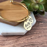 yellow gold charm bracelet with 1 charms. main charm is engraved with parents first name initial and wedding date. next one charms are engraved with child's birth month flower initial, and date of birth