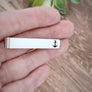 silver engraved Anchor on tie bar clip on woman's hand to show size