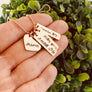 woman holding rose gold birth flower necklace with 3 name tags