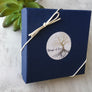 blue jewelry 3.5 inch X 3.5 inch jewelry box closed with a white bow stretch loop