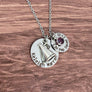 Round 7/8" silver stainless steel pendant engraved with coaches name "keleigh warren" A cheer megaphone charm lays on top of the name disc. Next to the name disc hangs a 5/8" round silver team name tag "LJH Pep Squad 21-22". a February stone sits on top of that disc. all charms are added to a stainless steel cable chain with lobster clasp.