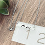 dophin necklace on ruler to show length of 1.25"