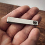 tie clip in woman's hand to show perspective