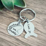 round silver stainless steel disc engraved with "hooked on daddy" and a reel and rod fishing pole. Attached next is a fish style name tag engraved with the kids name Luis Jr all charms are added on 1 " stainless steel keyring