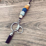 boho style lanyard with a burnt orange, navy blue, grey hexagon lanyard
