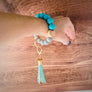 woman with the turquoise wristlet on to show size