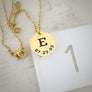 5/8" round yellow gold necklace with first name initial E and date of birth 7.23.03 on ruler to show measurement