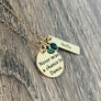 .75 inch yellow gold stainless steel round disc engraved with "never miss a chance to dance" a 6mm may green emerald birthstone and a 1.2 inch rectangle tag engraved with the name Stella