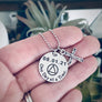 one day at a time engraved on a round 7/8" round pendant with AA symbol and cross charm necklace. necklace on woman's hand to show size