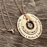 Rose Gold Pendant necklace. engraved Outer 1.25 inch hollow round disc engraved with "The love between a mother & daughter lasts forever" Small 1 inch hollow round disc engraved with 12.27.90 a outline of a heart the name Mya outline of a heart and 07.04.17. A December teal birthstone dangling in the center. Angel wing is attached to the 2 disc hollow pendants and adorned with a stainless steel cable chain.