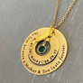 Yellow Gold Pendant necklace engraved Outer 1.25 inch hollow round disc engraved with "The love between a mother & son lasts forever" Small 1 inch hollow round disc engraved with 05.07.76 a outline of a heart the name Rocky outline of a heart and 8.28.17. A May green birthstone dangling in the center. Angel wing is attached to the 2 disc hollow pendants and adorned with a stainless steel cable chain.