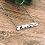 silver stainless steel bar necklace engraved with "mama wolf" a mom wolf image and 3 wolf cubs. attached to a silver stainless steel cable chain with lobster clasp