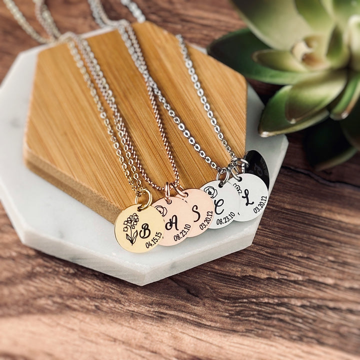 3 seperate necklaces showing the color options of silver, rose and yellow gold. Each necklace is engraved with your child's birth month flower, first name initial, and date of birth