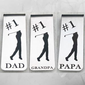 Silver stainless steel Money Clip with image of golfer swinging his club. 3 different options include #1 Dad, #1 Grandpa, #1 Papa. Money clip 1 inch by 2 inches