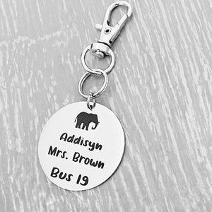 silver engraved stainless steel backpack tag keychain. engraved with a Elephant Image, Name Addisyn. Teachers name Mrs Brown and Bus 19