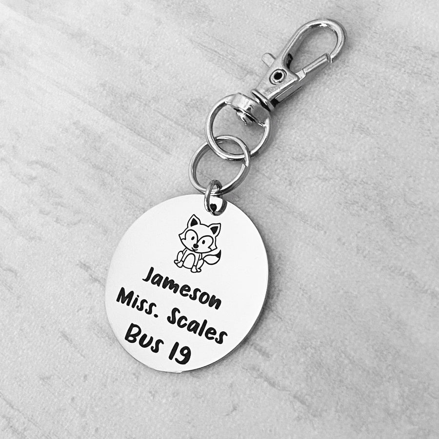 silver engraved stainless steel backpack tag keychain. engraved with a Fox Image, Name Jameson. Teachers name Miss Scales. and Bus 19