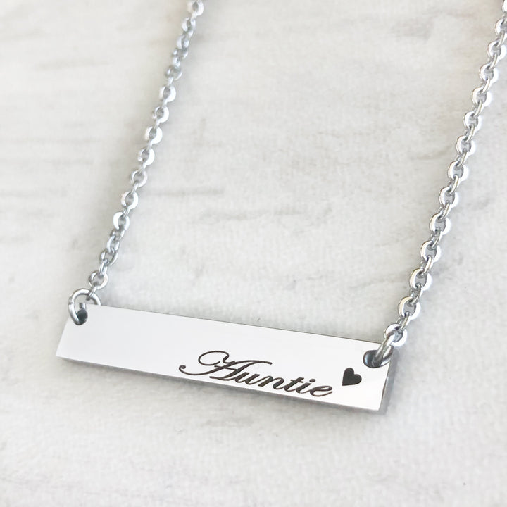Shiny silver bar necklace engraved with auntie and a heart attached to a cable chain
