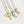 yellow gold, silver, and rose gold necklaces with a heart charm engraved with "mama". rectanagle tags are engraved with child's name and birth month flower