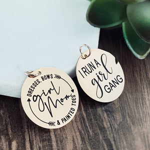 both generic charm tag options: "girl mom. dresses. bows & painted toes" and "I run a girl gang"
