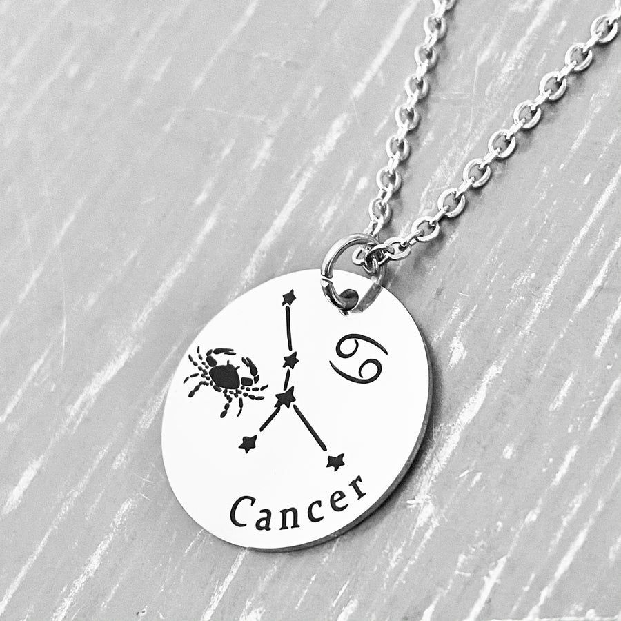 silver stainless steel 7/8" disc engraved with Cancer, its constellation, symbol, and the crab. attached to a stainless steel cable chain with lobster clasp