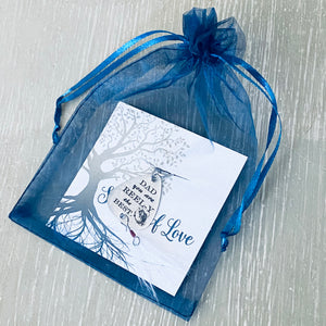Keychain packaged in a blue organza gift bag.