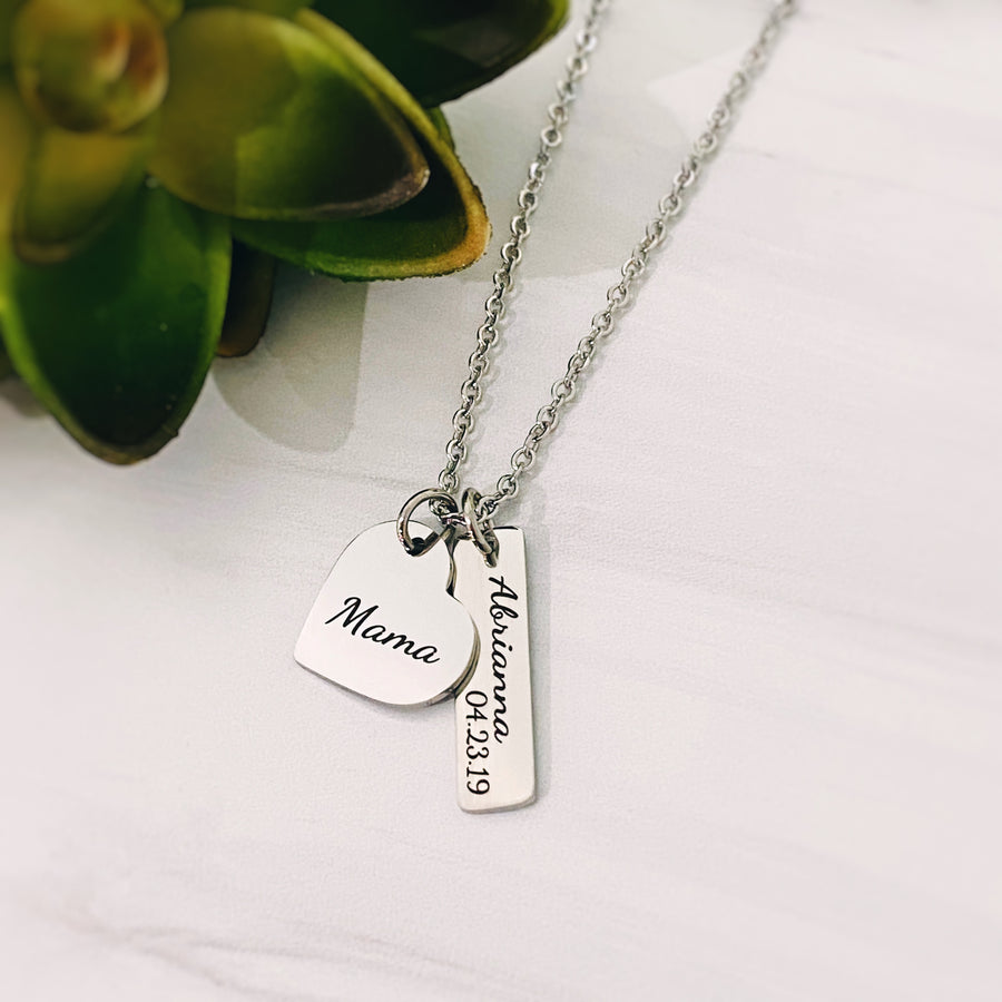 silver "mama" heart charm necklace with 1 rectangle name tage engraved with "abrianna" and the birthdate 4.23.19