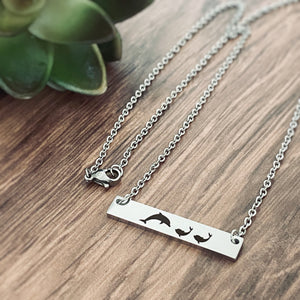 Silver Dolphin Horizontal Bar Necklace Engraved with 1 mom dolphin and 2 baby dolphins right side view