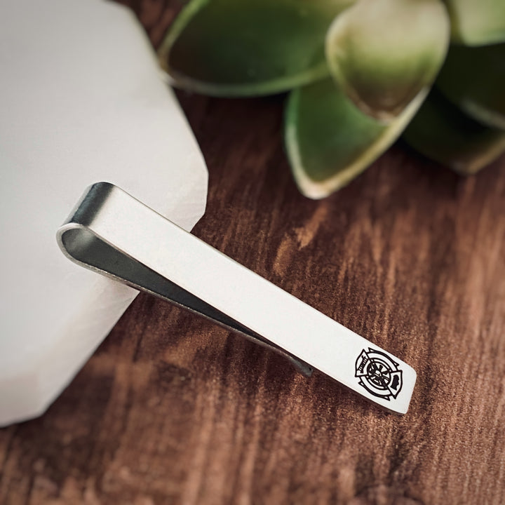 silver stainless steel tie clip engraved with the firefighter maltese cross symbol