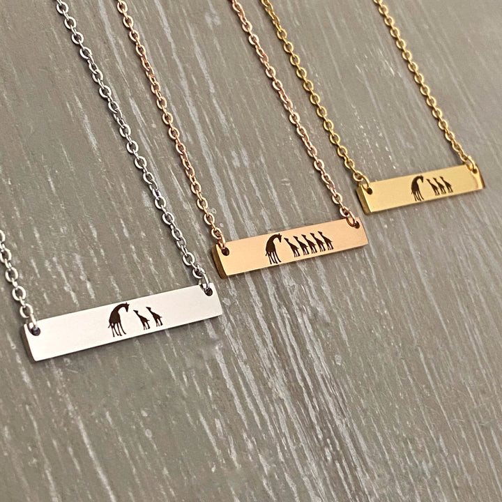 Mama Giraffe with 2 babies engraved on silver bar necklace. Mama Giraffe with 5 babies engraved on rose gold bar necklace. Mama Giraffe with 3 babies engraved on yellow gold bar necklace.