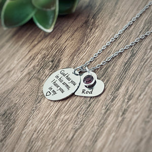 Silver stainless steel engraved Necklace with 3/4 inch round pendant engraved with "God has you in his arms, I have you in my heart". Next to the disc is a 3/4 inch heart engraved with Rod and a purple february amethyst stone. Pendants are attached to a cable chain