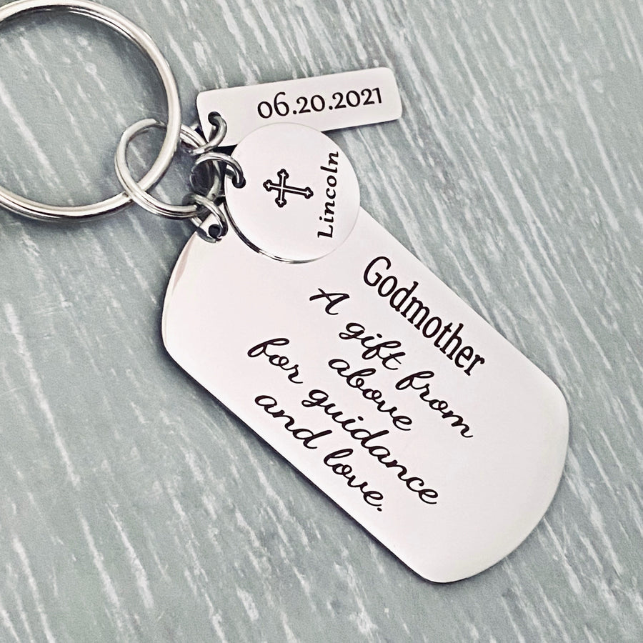 Silver Stainless steel dog tag keychain with black engraving phrase "Godmother. A gift from above for guidance & love". A 5/8 inch round disc with a cross image and name Lincoln. Next is a rectangle tag engraved with the date 6.20.21. All charms are attached to a 1 inch keyring