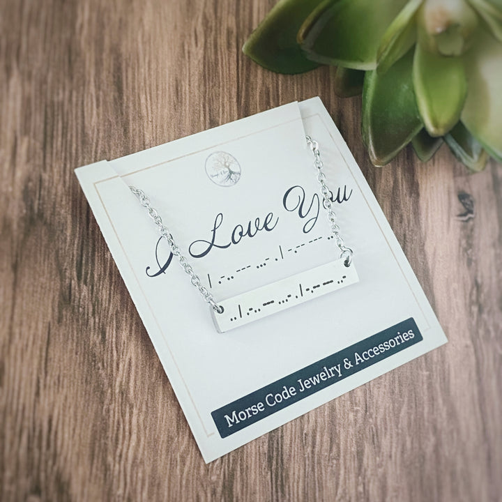 Silver horizontal engraved morse code necklace "I love You" on a packaging card.