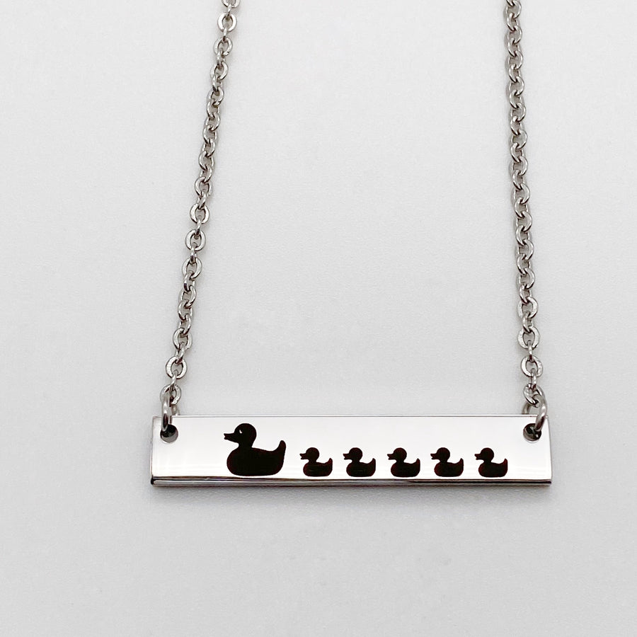 Silver duck necklace engraved with mom duck and 5 baby ducklings attached to a cable chain with lobster clasp