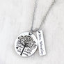 A 1-inch round stainless steel silver disc engraved with a tree of life symbol and the verbiage "it takes a BIG heart to shape little minds." Next to the disc is attached a 1-inch rectangle tag engraved with the name "Mrs. Wheatly". Both Charms are attached to a silver cable chain