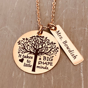A 1-inch round stainless steel plated rose gold disc engraved with a tree of life symbol and the verbiage "it takes a BIG heart to shape little minds." Next to the disc is attached a 1-inch rectangle tag engraved with the name "Mrs. Bowdish". Both Charms are attached to a rose gold cable chain