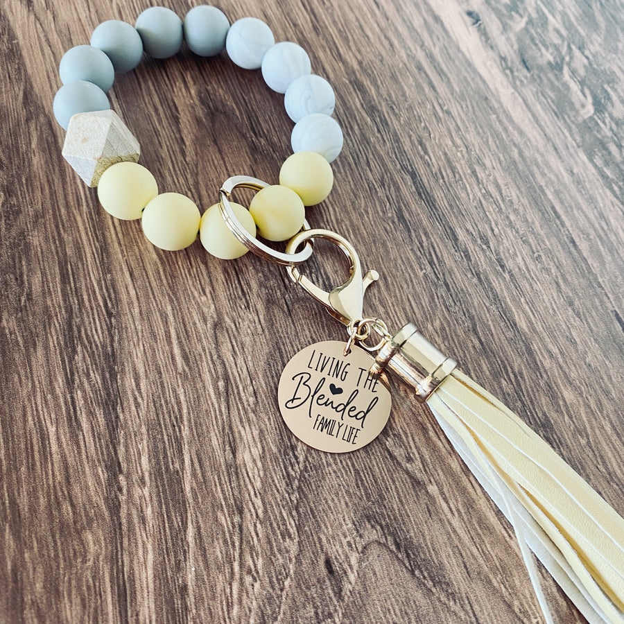 yellow silicone beaded round bracelet wristlet with charm tag engraved with "living that blended family life"
