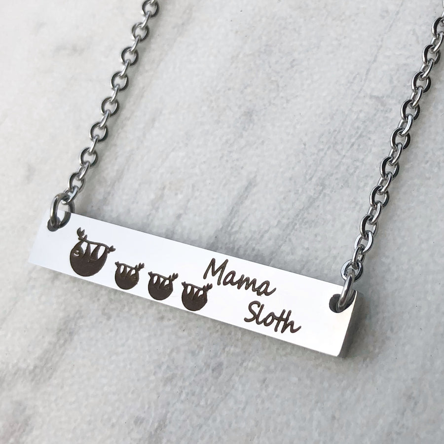 Silver horizontal bar necklace engraved with a mom sloth and 3 baby sloths along with "mama sloth" on cable chain