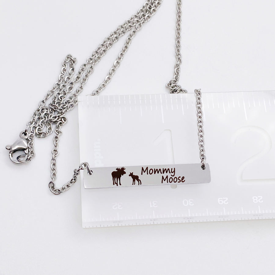 Silver Engraved Mommy Moose Bar Necklace with black engraved mom moose and baby fawn showing on ruler 1.5 inches wide with stainless steel cable chain