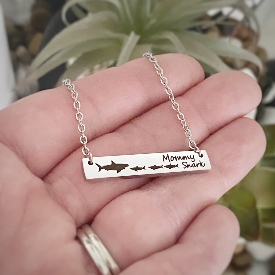 engraved mommy shark horizontal silver bar necklace attached to a stainless steel cable chain