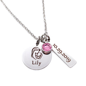 stainless steel silver round pendant engraved with an image of a mother holding a baby and the name Lily. Next to it is a 1 inch rectangle with the birthdate 10.29.2019 and a pink october birthstone. the charms are attached to a cable chain