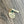 .75 inch yellow gold stainless steel round disc engraved with "never miss a chance to dance" a 6mm may green emerald birthstone and a 1.2 inch rectangle tag engraved with the name Stella