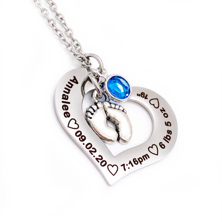 Silver Stainless Steel Open heart pendant attached to a silver cable chain. Baby feet charm and september birthstone attached. Black engraving around the heart charm with the name annalee, birthdate 09.20.20, time of birth 7:16pm, weight 6 lbs 5 oz, and length of 19" Side View