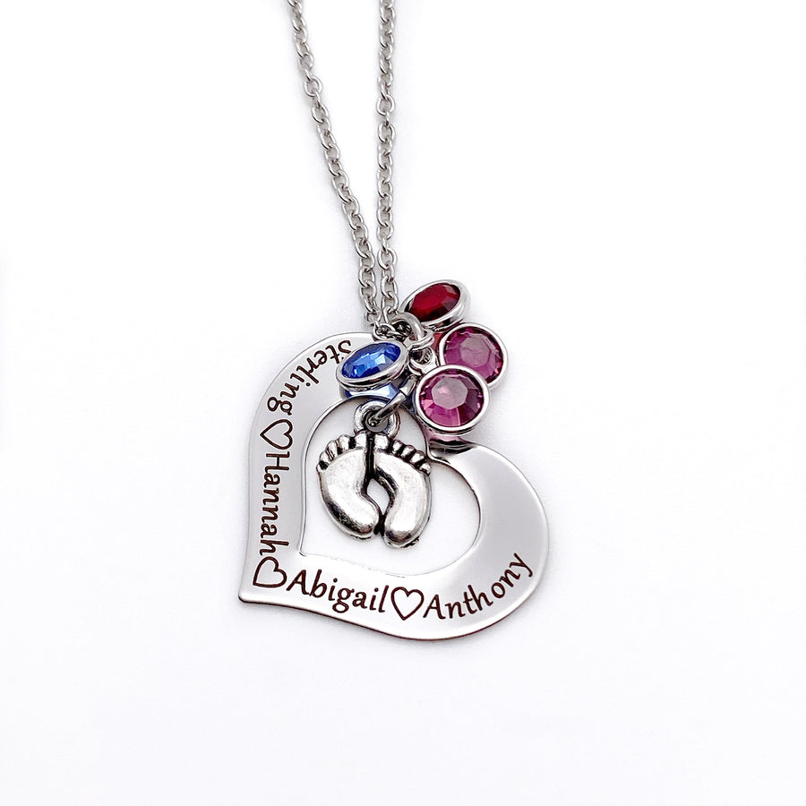 silver open heart necklace engraved with children's names and birthstones. a feet charm hangs in the center of the heart and birthstones