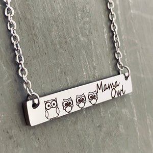 Left side view of a Silver horizontal bar necklace engraved with one mom owl and 3 baby owlets. The bar is attached to a silver stainless steel cable chain