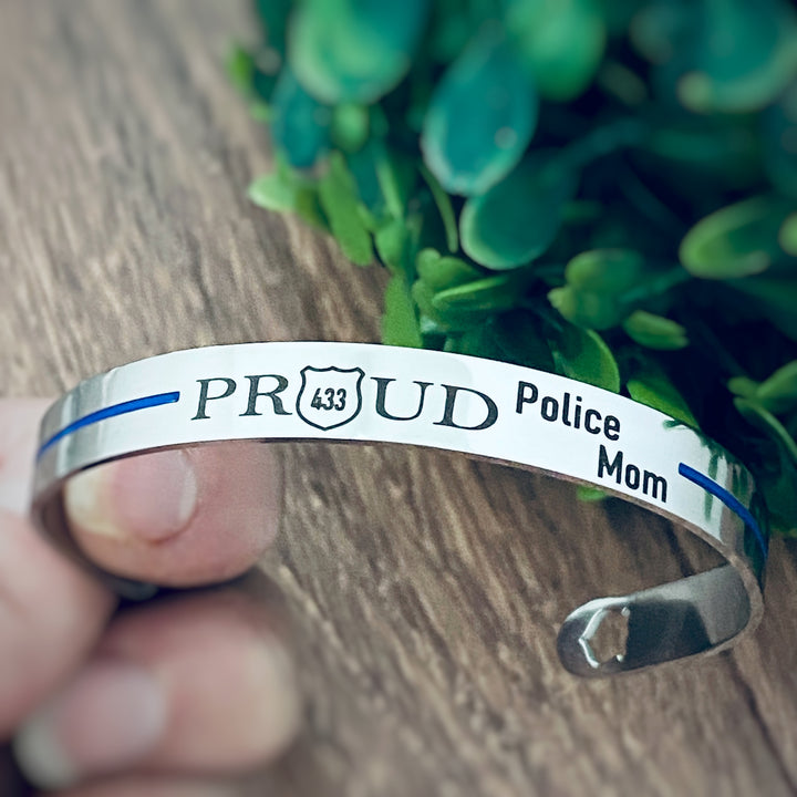 silver thin blue line stainless steel cuff bracelet engraved with the phrase "PROUD Police Mom" and the badge number 433