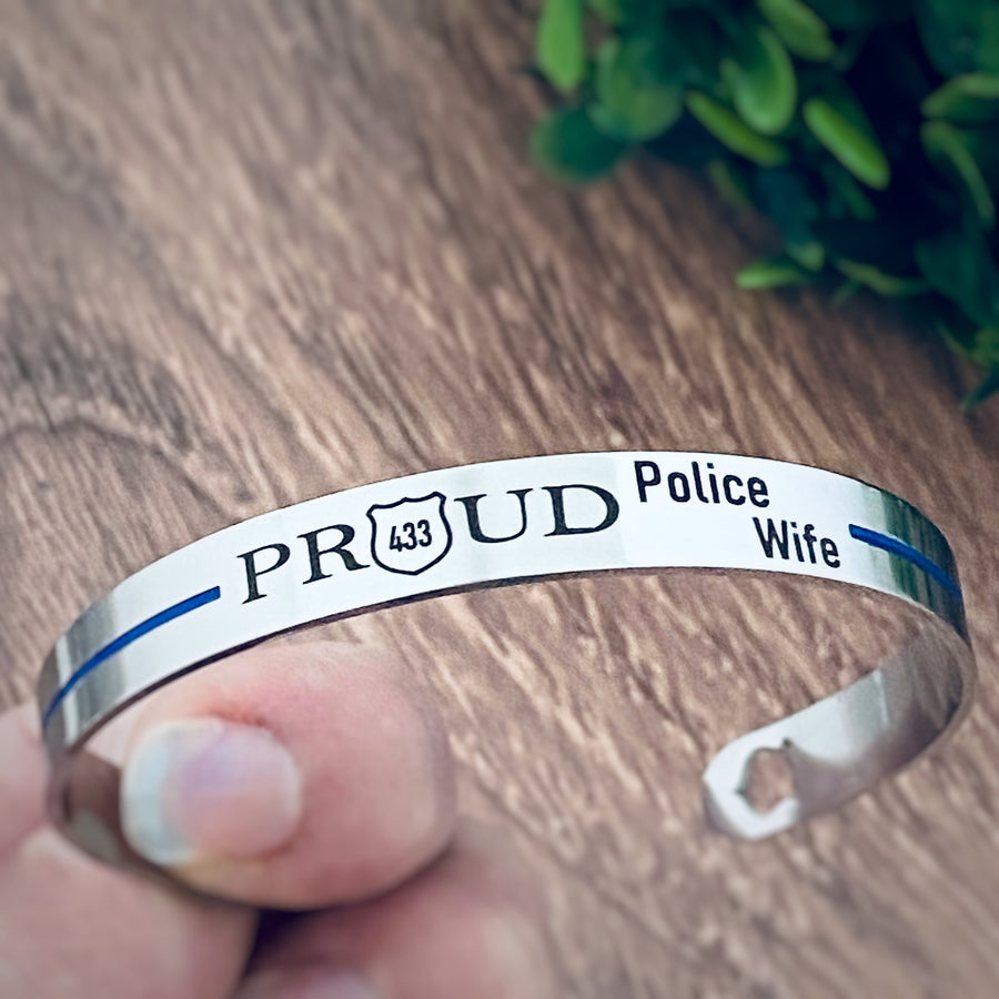 silver thin blue line stainless steel cuff bracelet engraved with the phrase "PROUD Police Wife" and the badge number 433