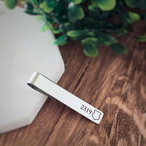 shiny stainless steel silver tie bar clip engraved with an outline of a police badge image and badge number 2319