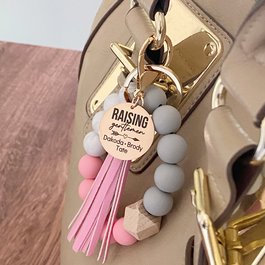 pink silicone wristlet on purse with raising gentlemen charm 