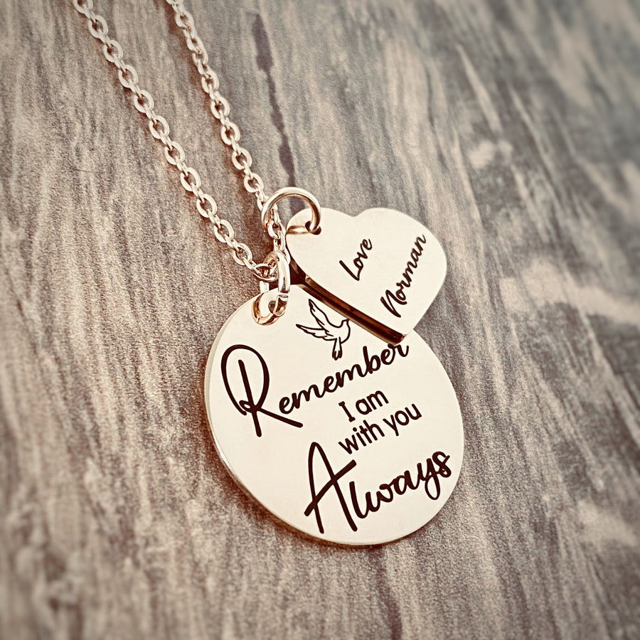 Rose Gold Memorial Necklace engraved with a dove bird and the phrase "Remember I am with you Always". next to the round pendant is a heart charm engraved with "Love norman" both charm endants are attached with a cable chain with lobster clasp